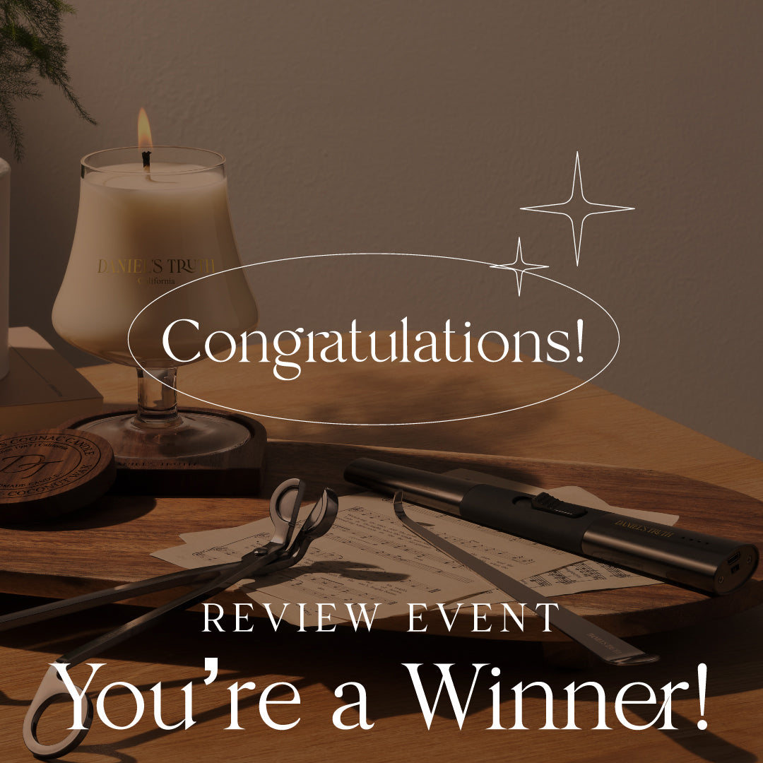 Scented candle, candle tools, and congratulatory review event winner message on wooden tray.